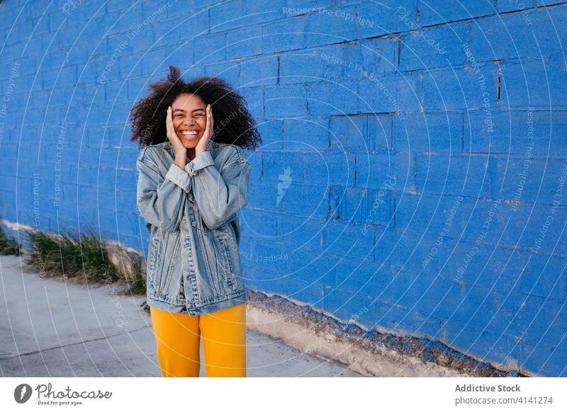 Cheerful woman smiling and grimacing on street smile cheerful grimace afro denim millennial city vivid bright female black african american ethnic vibrant color
