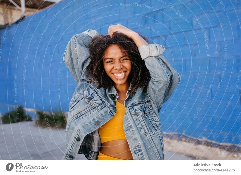 Cheerful woman smiling and grimacing on street smile cheerful grimace afro denim millennial city vivid bright female black african american ethnic vibrant color