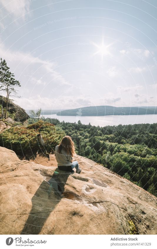 Relaxed woman enjoying view from mountain forest nature relax sit travel hike algonquin provincial park landscape lake river sunny admire tranquil harmony