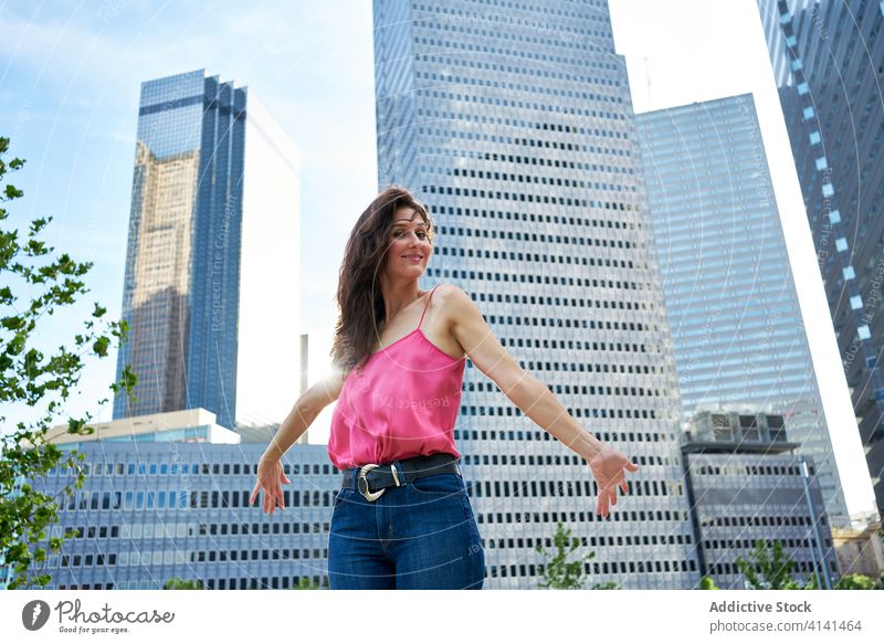 Determined smiling businesswoman against skyscrapers in downtown determine professional confident city entrepreneur high rise elegant female urban manager