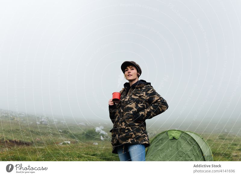 Woman in outerwear near camping tent in nature woman highland content relax traveler stand morning fog wanderlust mist freedom landscape harmony joy casual