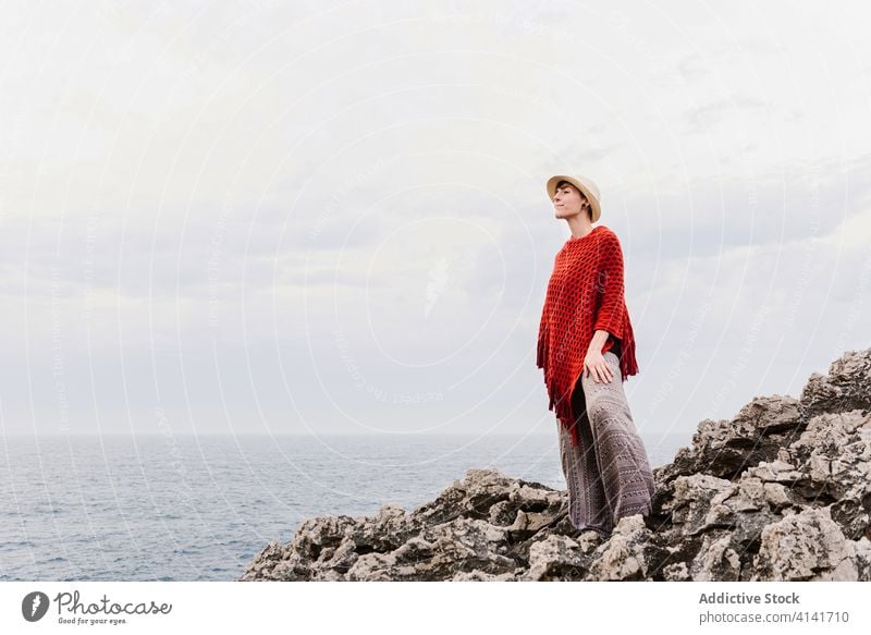 Stylish female tourist enjoying seascape from rocky cliff woman coast travel admire nature freedom relax jesters of arenillas spain asturias llanes style