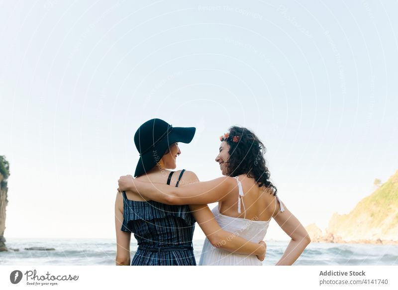 Unrecognizable lesbian couple embracing near ocean during honeymoon in summer girlfriend embrace love bonding sea romance relationship harmony fondness