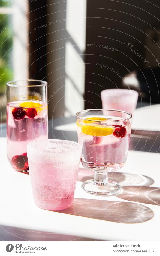 Glasses of fresh infused water on table detox drink fruit lemon healthy vitamin natural nutrition modern apartment beverage organic glass mint cherry summer