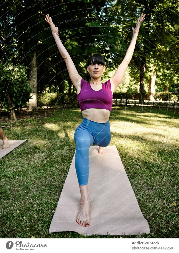 Calm woman practicing yoga in crescent pose crescent variation lunge high lunge female park barefoot sunny training eyes closed tranquil healthy serene
