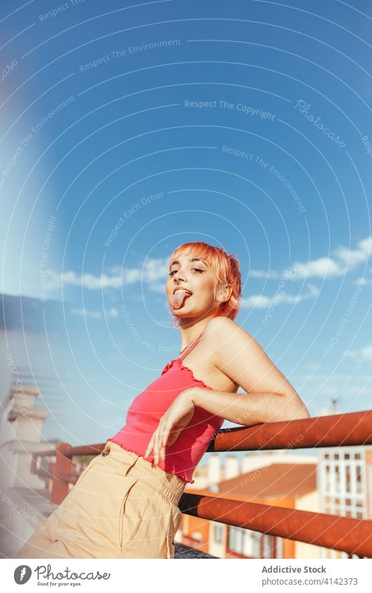 Happy woman looking at camera millennial expressive pink hair different female summer railing city lean cheerful freedom glad urban delight lady happy style