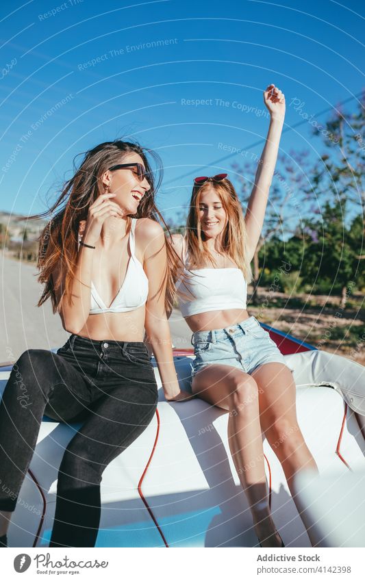 Delighted girlfriends having fun in summer on road vacation enjoy women cabriolet car carefree cheerful together holiday smile happy travel sit freedom nature