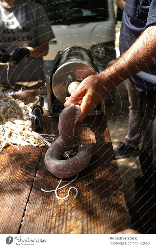 Crop male worker filling chorizo sausage in traditional way man fresh meat natural production factory prepare food local butcher raw ingredient meal industry