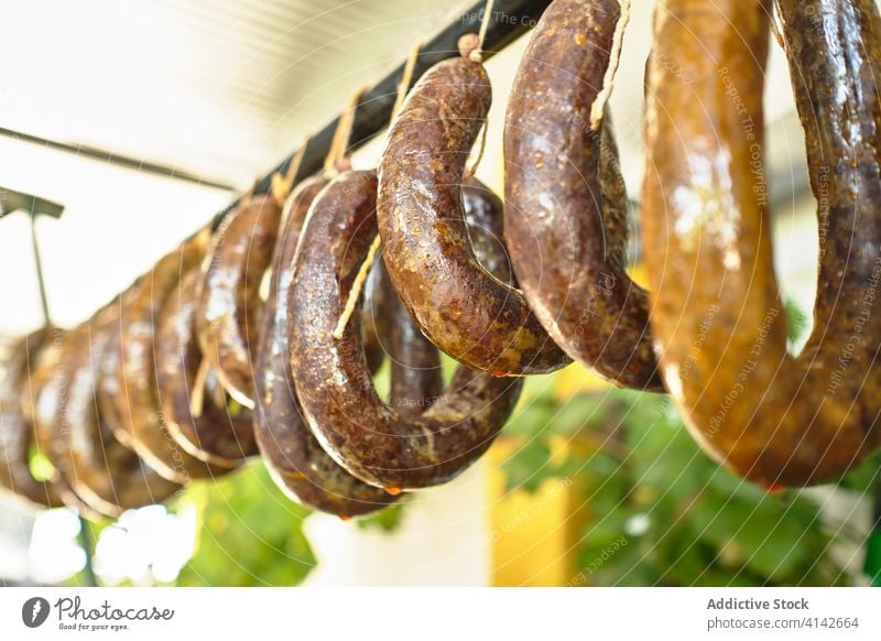Fresh meat sausages hanging on rack and curing local factory chorizo homemade fresh production tradition food delicious spanish cuisine tasty gourmet rustic