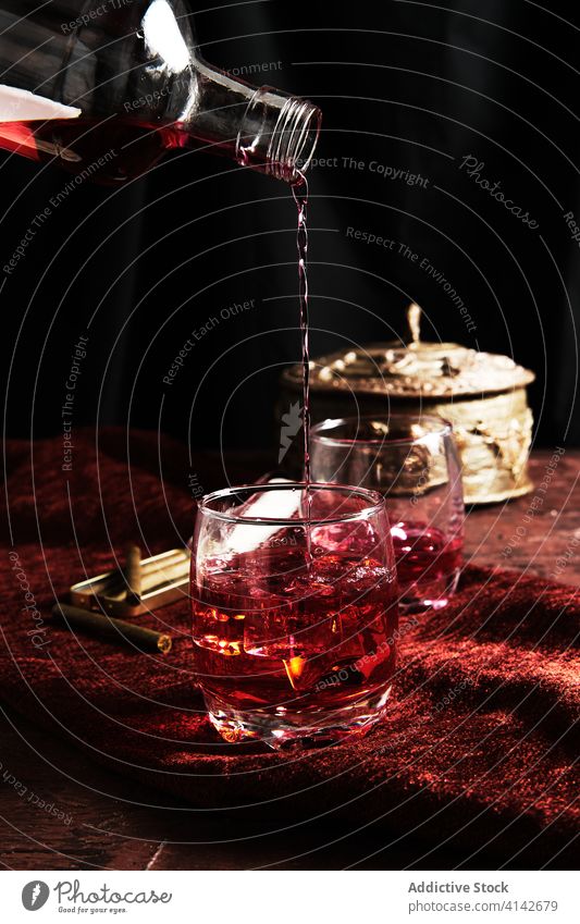 Anonymous person serving whiskey in a glass alcohol ice scotch whisky liquor background cold single brandy drink liquid reflection cube yellow isolated brown