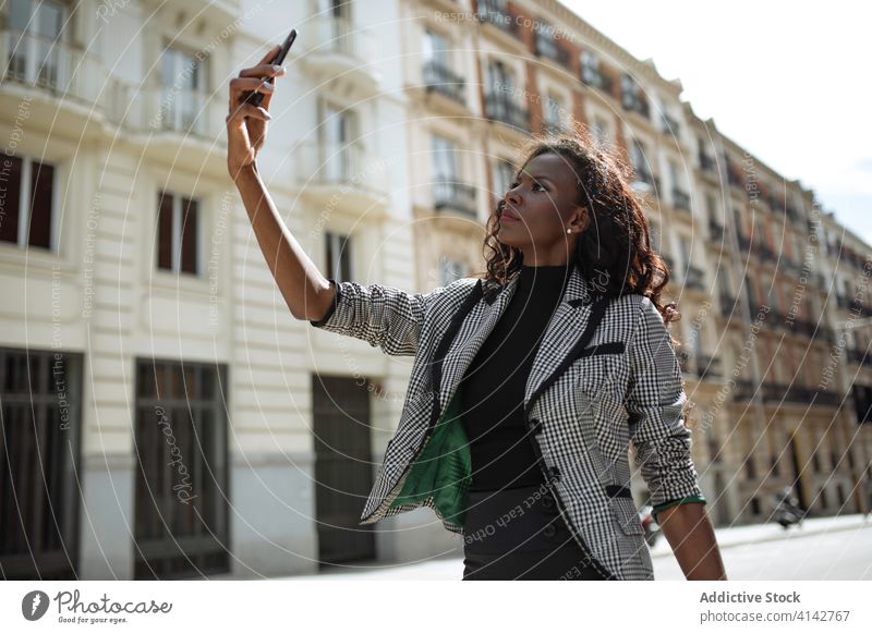 Young woman in stylish suit taking selfie on street businesswoman smartphone city urban formal confident young african american black ethnic elegant