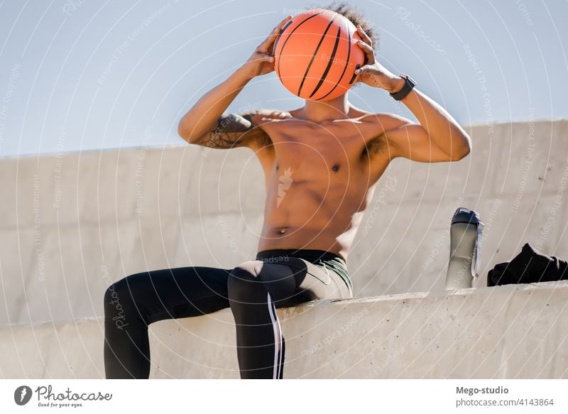 Afro athletic man relaxing after training. sport athlete basketball urban outdoor standing enjoy expression outdoors active hand exercise recreation sports