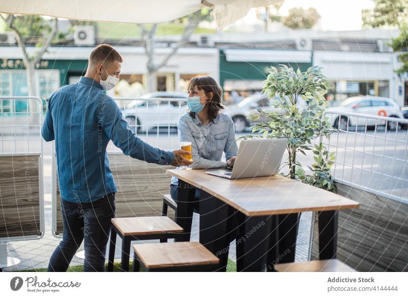 Female working on laptop in street cafe and waiting for order people serve beer fresh waiter client freelance coronavirus beverage device occupation job remote