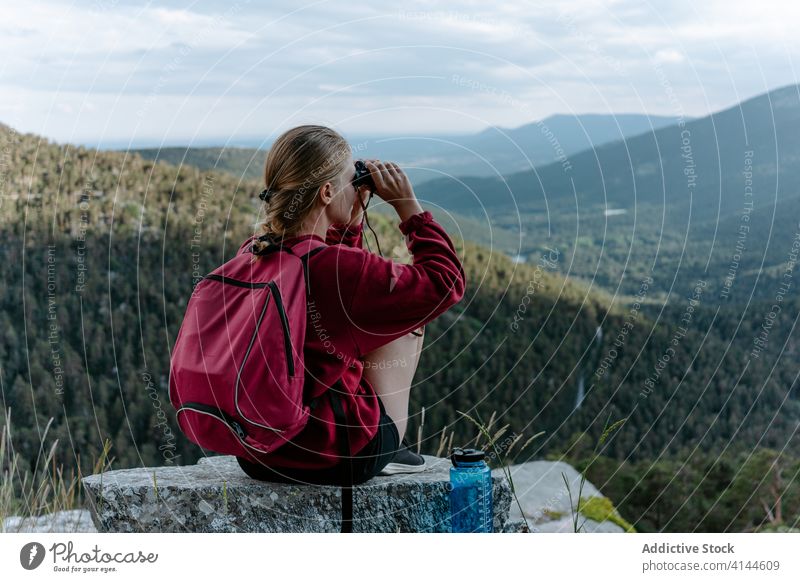 Female hiker with binoculars enjoying mountain landscape woman hill explore travel activity backpacker nature discovery forest trekking young adventure spain