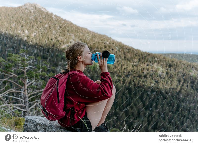 Traveler with bottle of water resting in mountains woman drink hike forest refresh activity travel trekking nature adventure spain navacerrada madrid female
