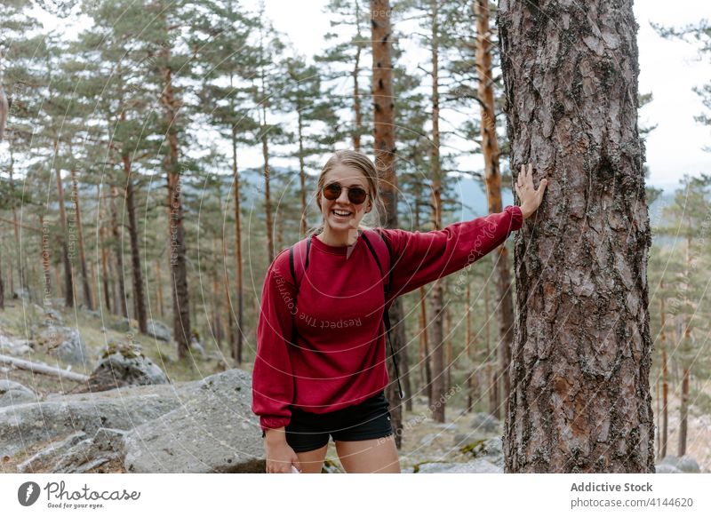 Woman leaning on trunk of a tree in forest woman hike travel stone activity trekking young nature adventure spain navacerrada madrid female hiker journey happy