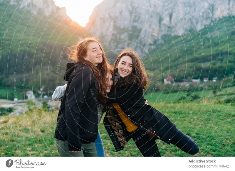 Cheerful female friends hugging in mountains together vacation friendship girlfriend unity highland transylvania romania saint george amazing embrace happy