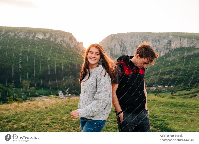 Friendly man and woman in highlands mountain sunset friend vacation picturesque landscape together meadow travel summer holiday content freedom nature carefree
