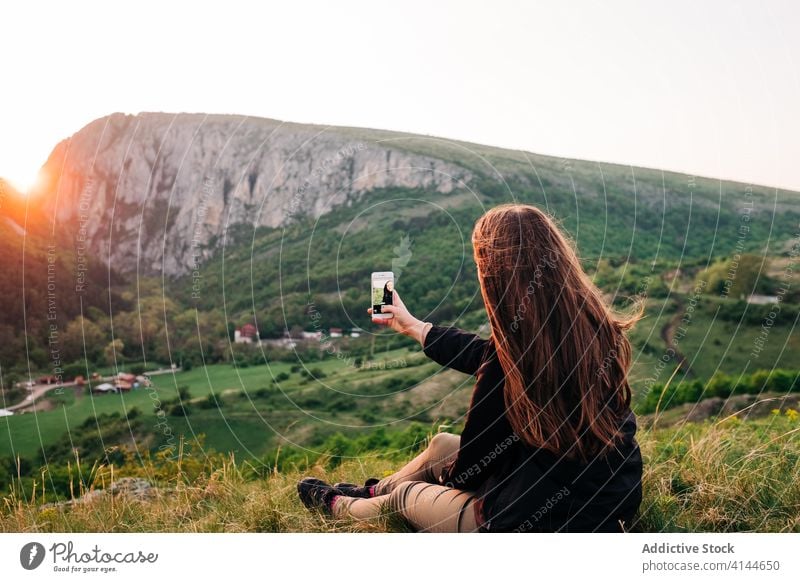 Traveling woman taking selfie on smartphone in mountains tourist vacation relax using memory highland female transylvania romania saint george gadget device
