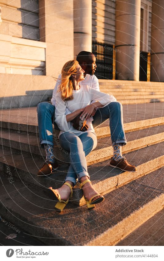 Romantic couple resting on old building steps in evening sunlight hug bonding romantic content tender stair sunset picturesque eyes closed madrid spain fondness