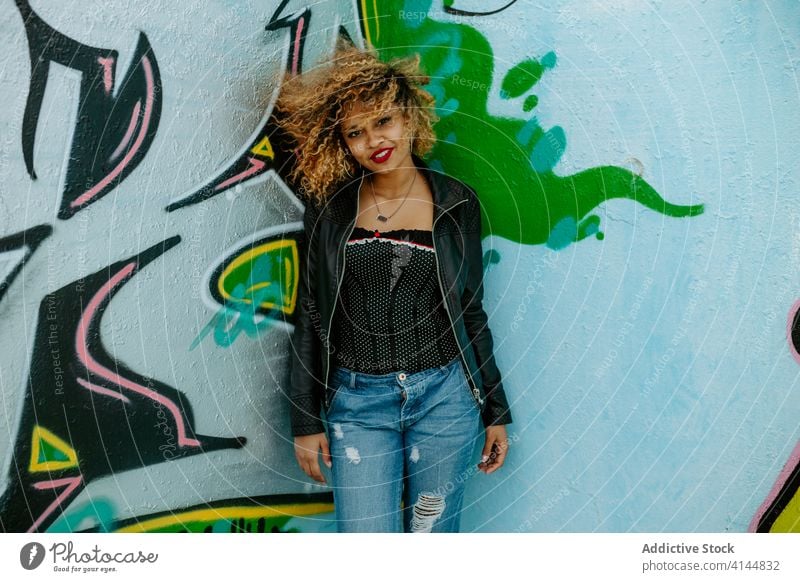 Young smiling woman near graffiti wall style millennial creative city urban trendy smile positive female ethnic black african american young street relax happy