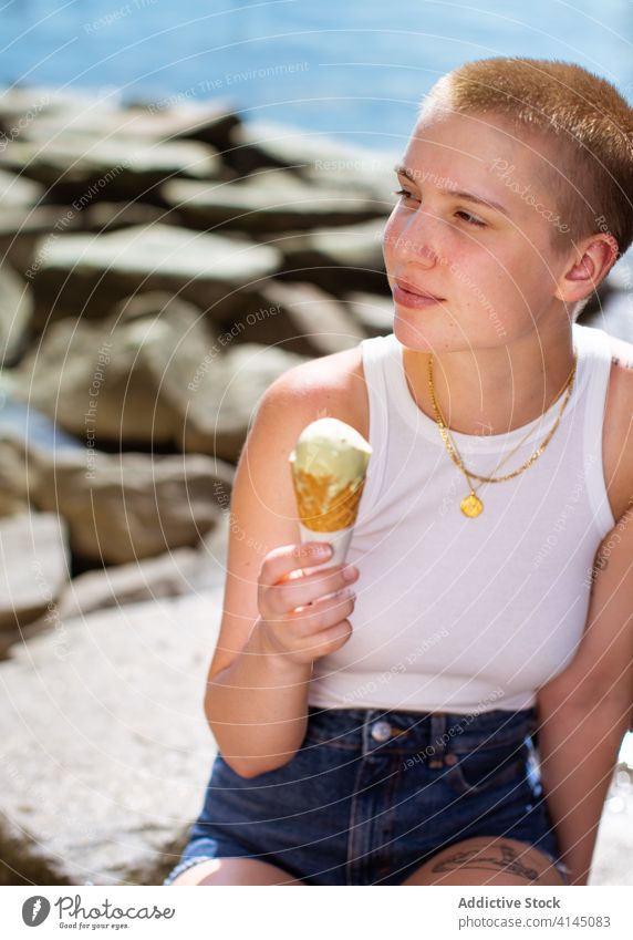 Young woman with ice cream eat street summer young subculture shaved dessert cold female short hair appetizing appearance individuality personality cone sunny