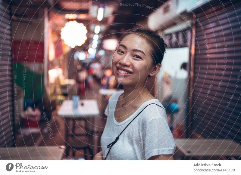 Positive Asian woman standing in cafe happy smile street city night young positive cheerful urban glad joy asian female ethnic casual lifestyle illuminate