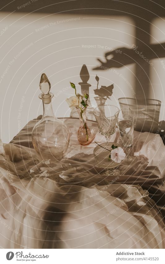 Elegant table decoration with glassware and fragrant white flowers vase decanter elegant delicate composition shadow hand design vintage classic feminine bloom