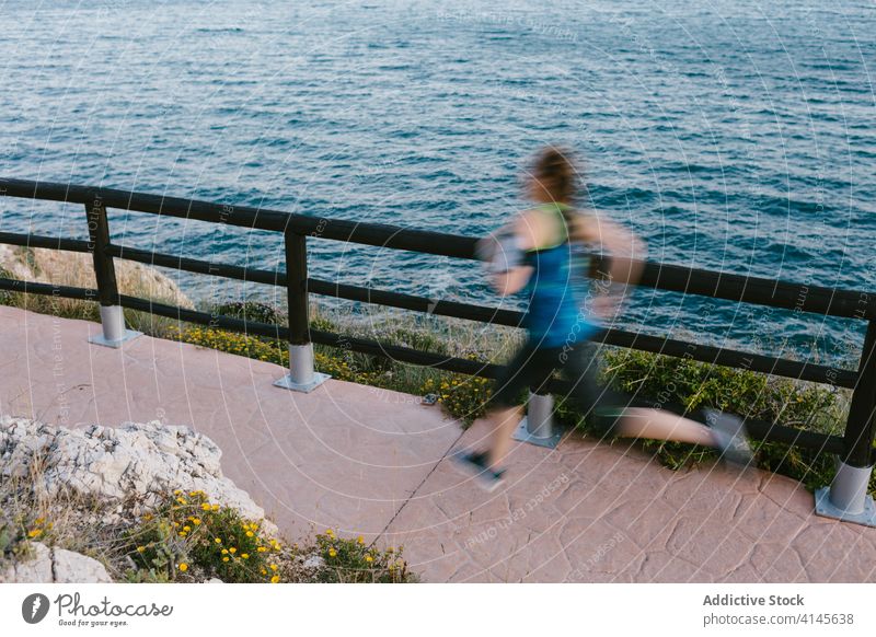 Sportive woman running fast along seafront morning training runner speed sporty female sportswoman promenade activewear athlete fitness sportswear energy