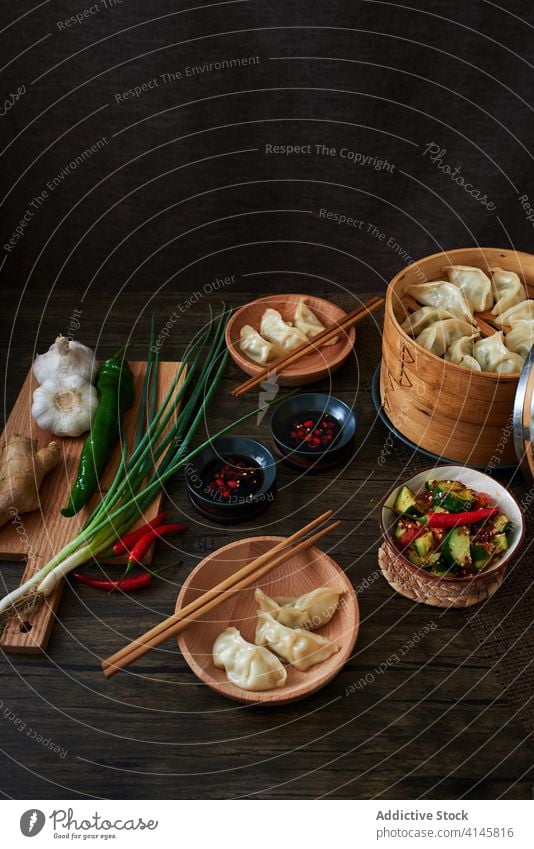 Chinese steamed dumplings xiaolongbao jiaozi chinese food yummy wood dark food vegetables salad cucumber foodie tradition traditional Asia Asian food chopsticks