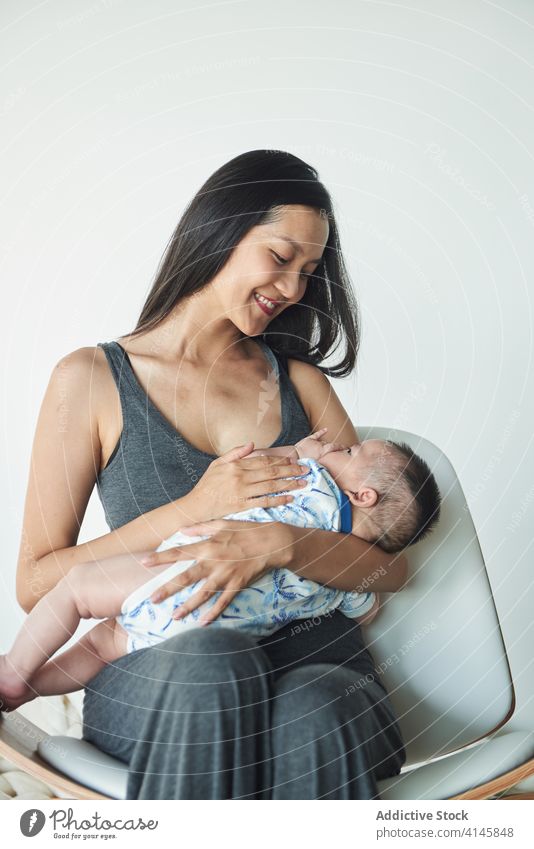 Mother holding her son at home family baby child boy mom mother fun enjoy stay at home beautiful model portrait flat people happy family caucasian chinese