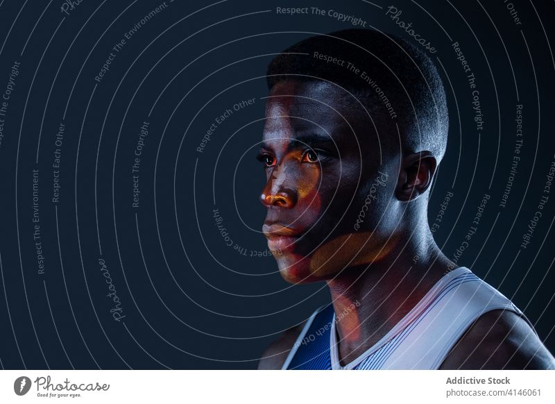 Confident black sportsman in neon illumination athlete confident brutal competitive determine portrait red active physical young african american ethnic male