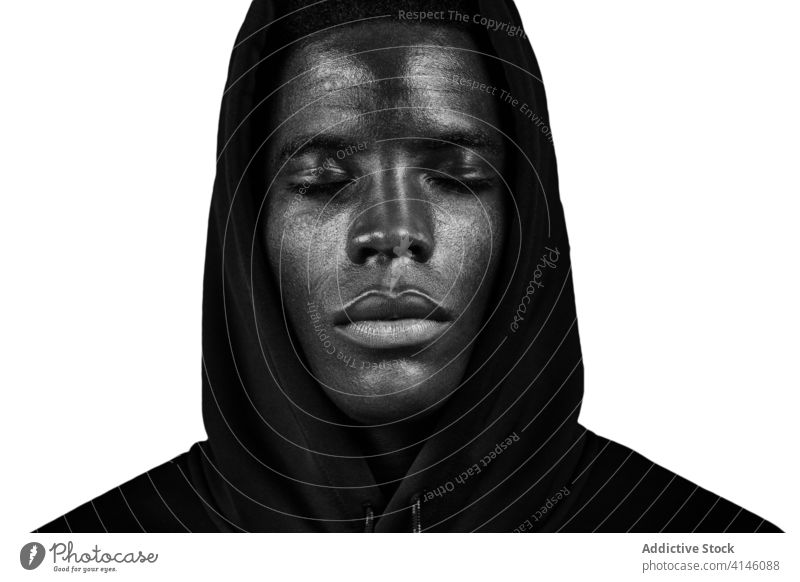 Black man in hood in studio black hoodie young eyes closed emotionless calm modern portrait male african american ethnic head human face tranquil unemotional