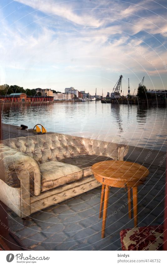 Illusion l Reflection in a window pane at the harbour of Lübeck, couch and coffee table at the quay of the harbour Harbour reflection Window wharf Deception