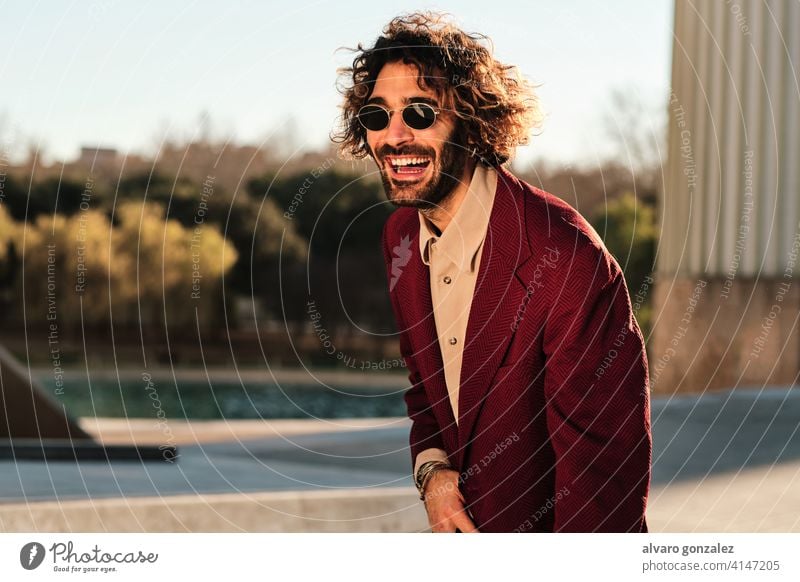 Confident man smiling while standing outdoors. portrait hipster urban street clothes stylish city trendy clothing confidence style coat sombrero one confident
