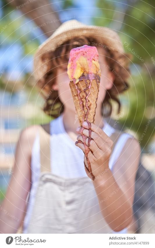 Delighted boy with tasty ice cream cone melt pleasure glad weekend vacation summertime dessert nature treat child delicious food yummy childhood street carefree