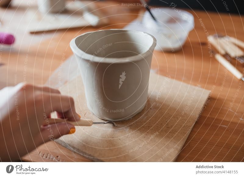 Crop craftswoman making ceramic cup in workshop create artisan clay tool handmade skill female professional mug job table creative hobby small business talent
