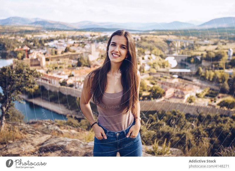 Smiling woman on background of cityscape style old hill sunny town building vacation female buitrago del lozoya madrid spain cheerful happy travel tourism smile