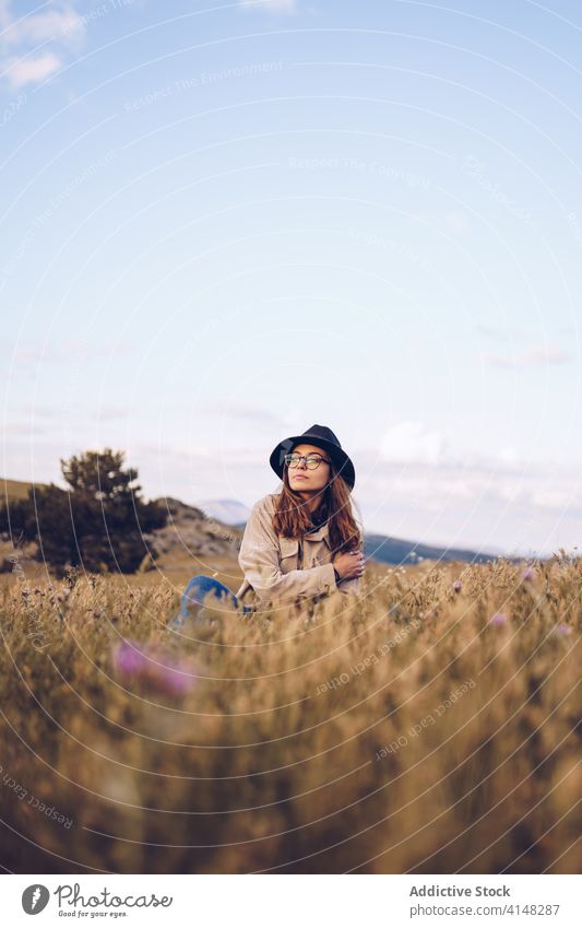 Calm woman relaxing in field autumn dried meadow nature serene rest harmony female peaceful fall sit grass season dry tranquil enjoy idyllic lady freedom