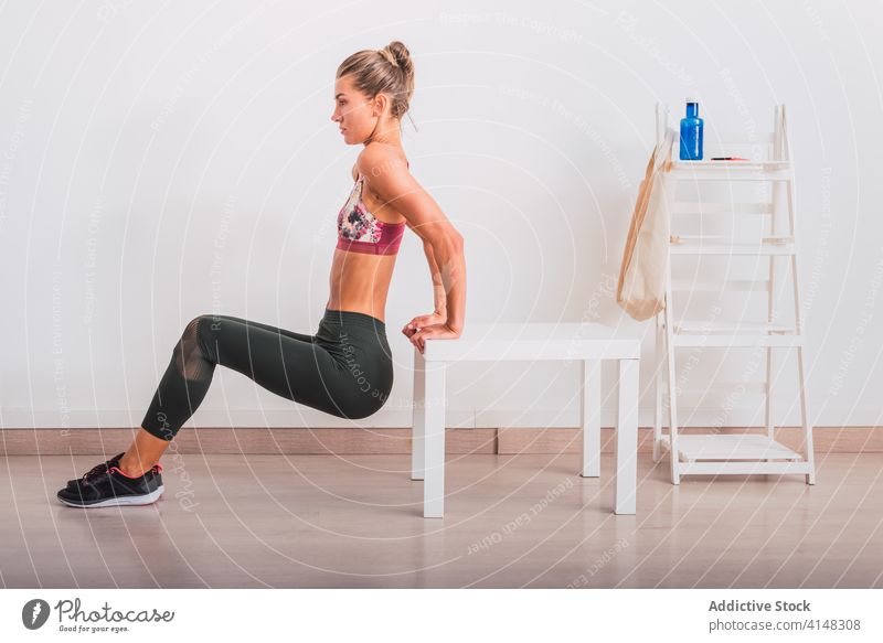 Slender sportswoman exercising leaned on small table in flat warm up exercise workout energy balance vitality determine concentrate parquet healthy practice