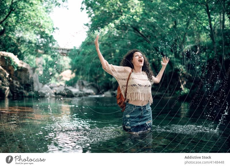 Content woman in river in forest enjoy vacation summer tourism cheerful holiday water female relax travel happy journey smile adventure carefree nature trip