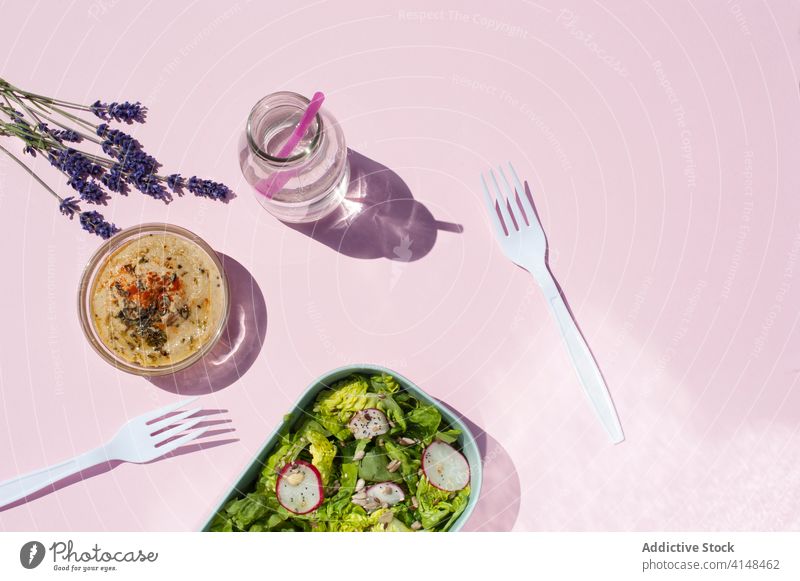 Healthy lunch on pink table in studio salad vegetable snack healthy serve fresh water natural healthy food lavender flower bottle bloom blossom plant organic