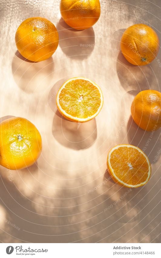Juicy oranges on pastel orange table in studio fresh fruit ripe vitamin natural half healthy organic food juice delicious modern diet tasty arrangement