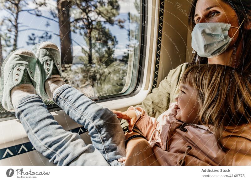 Mother and daughter in train travel window mother child together coronavirus mask protect passenger seat little girl journey epidemic medical calm kid transport