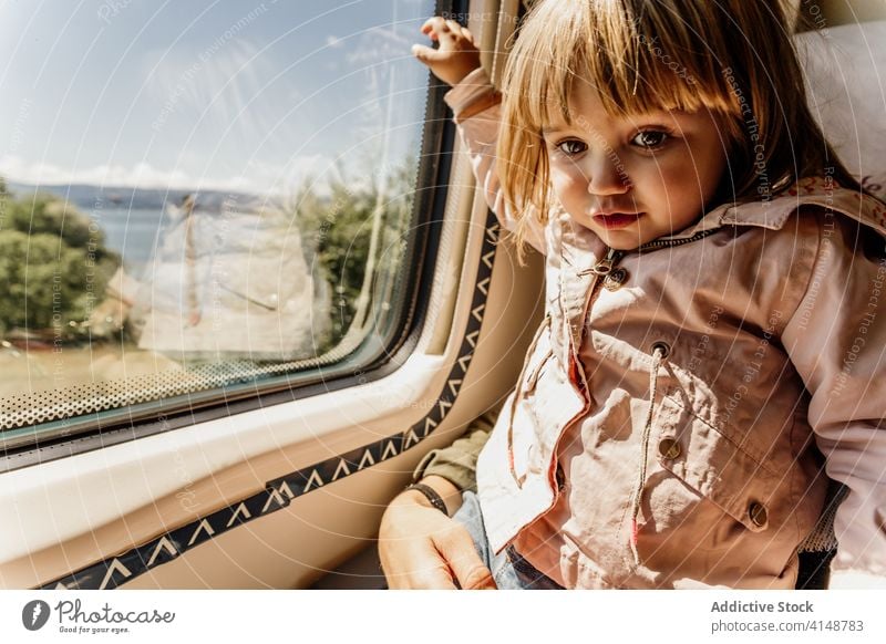 Mother and daughter in train travel window mother child together coronavirus mask protect passenger seat little girl journey epidemic medical calm kid transport