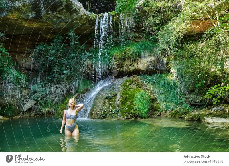 Woman in swimwear in lake waterfall forest woman enjoy bikini vacation traveler summer female holiday nature relax tourism adventure landscape green lady aqua