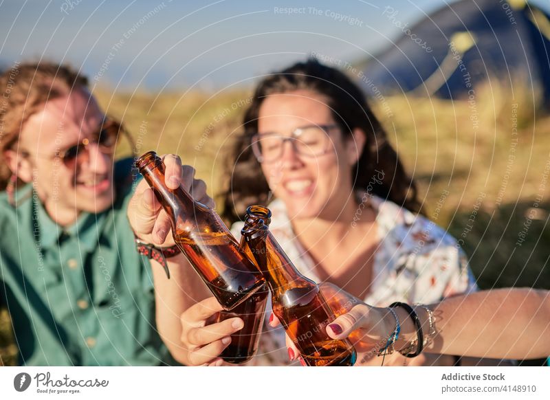 Friends clinking bottles in mountains enjoy weekend friend group relax alcohol summer highland company together beverage beer sunset drink rest cheers cheerful