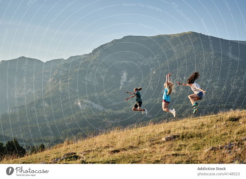 Carefree travelers jumping in highlands enjoy freedom carefree summer vacation friend group mountain happy moment together nature journey activity adventure