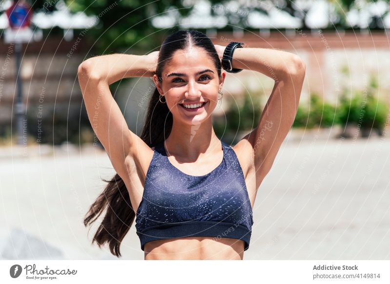 Sportswoman preparing for training in city prepare sportswoman ponytail workout strong fit muscular bra street healthy athlete stand vitality activity wellness