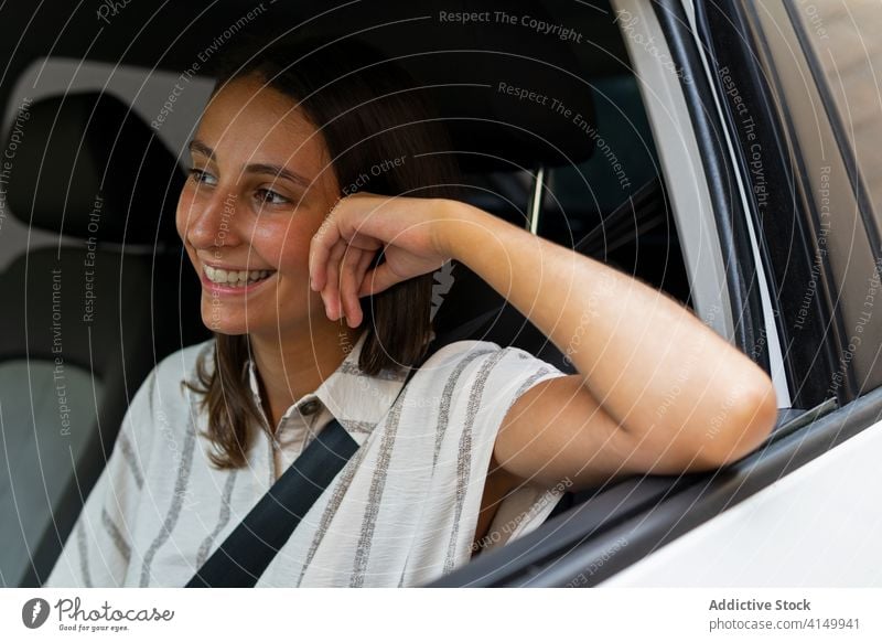 Cheerful woman driving car in city drive automobile driver transport smile young seat female daytime modern happy cheerful vehicle joy sit style street trip